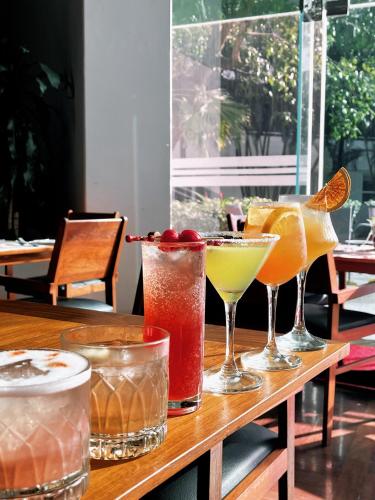 a wooden table with four different cocktails on it at Inya Lake Hotel Yangon in Yangon