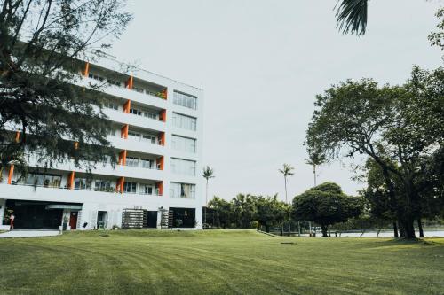 a white building with a grass field in front of it at Inya Lake Hotel Yangon in Yangon