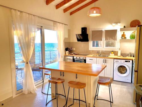 a kitchen with a counter and a table with stools at EuGeniaS Villa in Agios Gordios