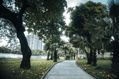 a walking path in a park with palm trees at Inya Lake Hotel Yangon in Yangon