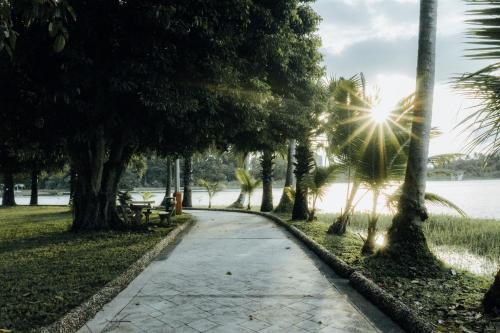 a walkway through a park with palm trees at Inya Lake Hotel Yangon in Yangon