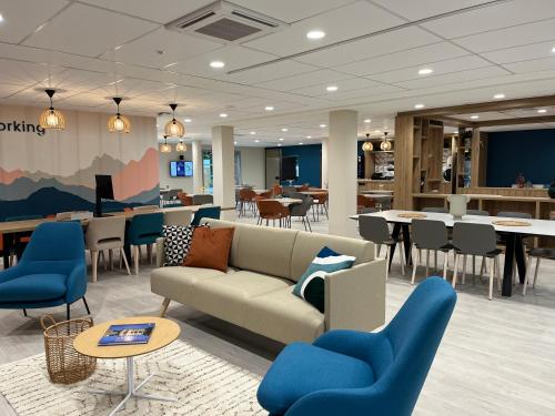 a lobby with a couch and chairs and tables at Oh Activ Tarbes in Tarbes