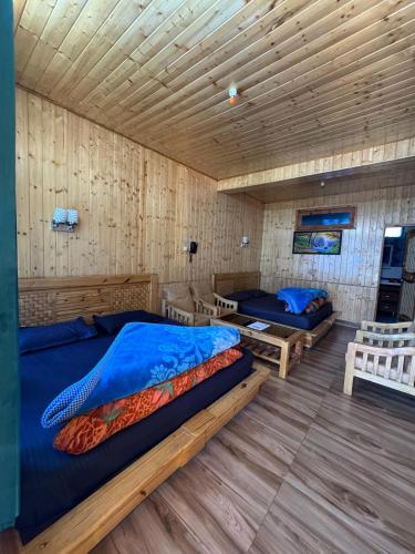 a bedroom with two beds and a wooden ceiling at Hotel 19 Tosh in Tosh