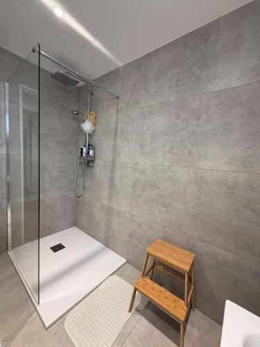 une salle de bain avec une douche et un tabouret dedans dans l'établissement Logement lumineux de 92m2, à Colmar