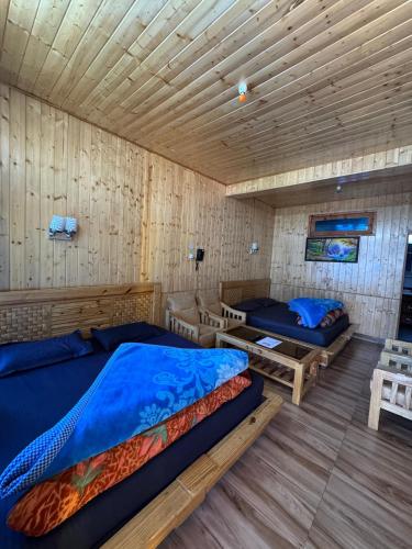 a bedroom with two beds and a wooden ceiling at Hotel 19 Tosh in Tosh