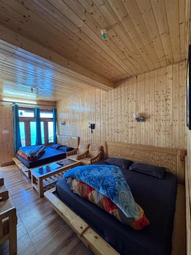 a bedroom with two beds in a wooden cabin at Hotel 19 Tosh in Tosh