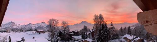 a view of a snow covered mountain with a sunset at Chalet La Renarde in Villars-sur-Ollon