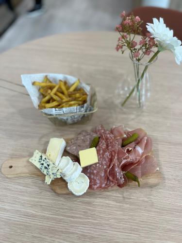 a table with meat and cheese and a bowl of french fries at Oh Activ Tarbes in Tarbes