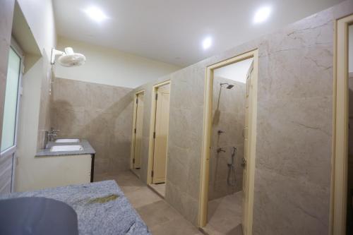 un baño con ducha y lavabo en Nilan Zingle Resort, en Pondicherry