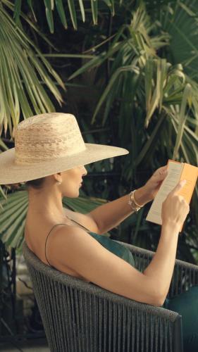 a woman wearing a straw hat reading a book at Montreux Luxury Suite in Montreux