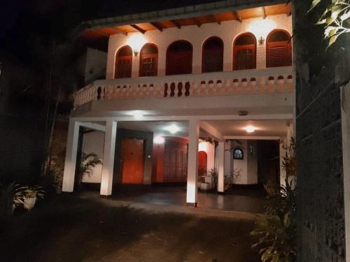 a large white house at night with lights at Ceylon Travel and Stay Lodge in Battaramulla