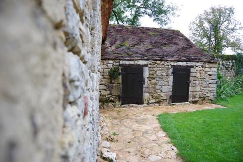 an outside view of a stone building with two doors at Demeure du Vallon - Chambres d'Hôtes de Charme in Azerat