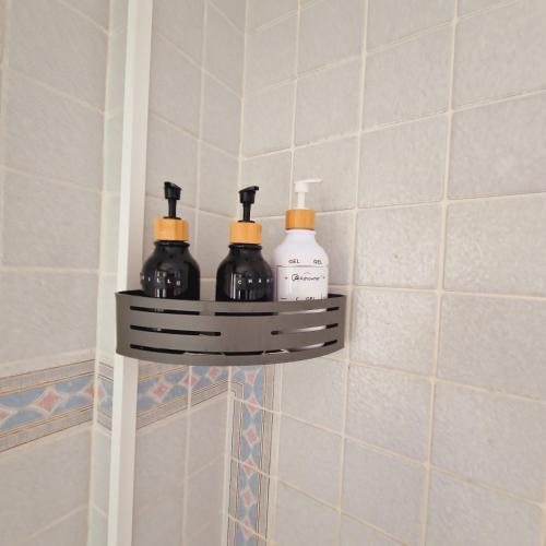 a shelf in a bathroom with four bottles on it at Chalet Playa Chilches in Chilches