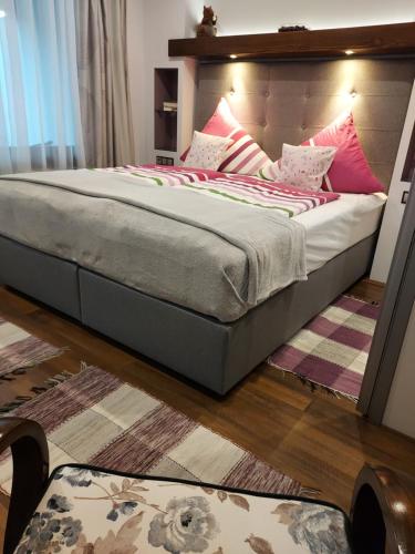 a bedroom with a large bed with a wooden headboard at Titi Boutique Apartmanok in Bükfürdő