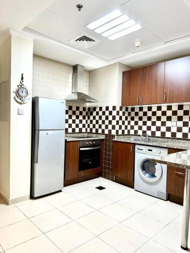 a kitchen with a refrigerator and a washing machine at Apartment in Al Barsha1 Near by Metro in Dubai