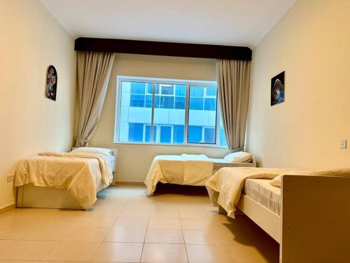 a hospital room with two beds and a window at Apartment in Al Barsha1 Near by Metro in Dubai
