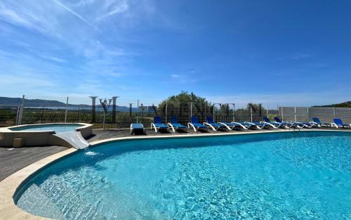 une grande piscine avec des chaises dans l'établissement Appartement Salduccio Piscine tennis mini golf LUMIO, à Lumio