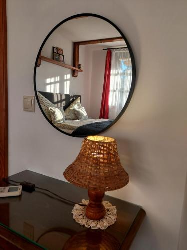 a mirror on top of a table with a lamp at Titi Boutique Apartmanok in Bükfürdő