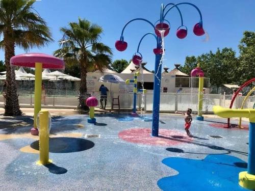un enfant jouant dans un parc aquatique dans l'établissement Mobil home F033 camping la carabasse 4 étoiles Vias, à Vias