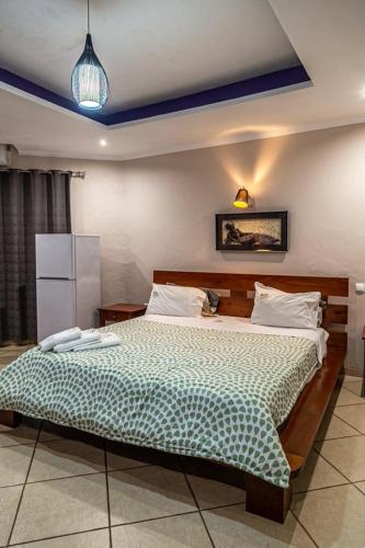 a bedroom with a large bed with a green comforter at Ossanzaia Bilene Lodge in Vila Praia Do Bilene