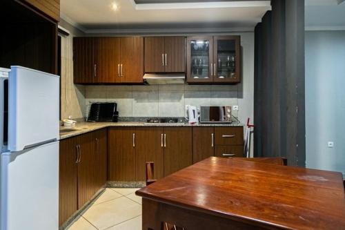 a kitchen with wooden cabinets and a wooden table at Ossanzaia Bilene Lodge in Vila Praia Do Bilene