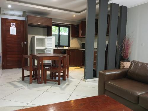 a kitchen and living room with a table and a couch at Ossanzaia Bilene Lodge in Vila Praia Do Bilene