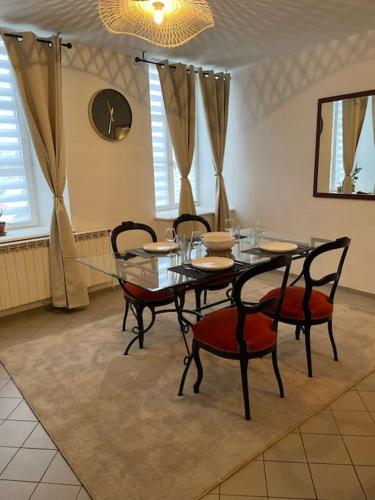 a dining room with a glass table and chairs at Le manoir étoilé in Neufchâteau