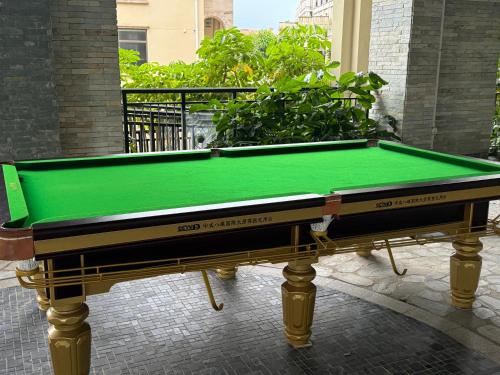 a green pool table sitting on a brick floor at 阿卡那拉橘子海亲子民宿 in Dapeng