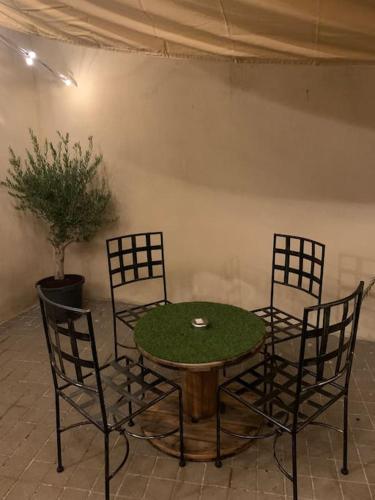 a table with four chairs and a table with a green table at Le manoir étoilé in Neufchâteau