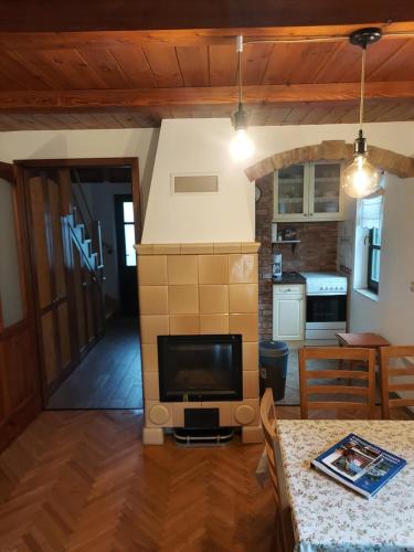 a living room with a television and a kitchen at Titi Boutique Apartmanok in Bükfürdő