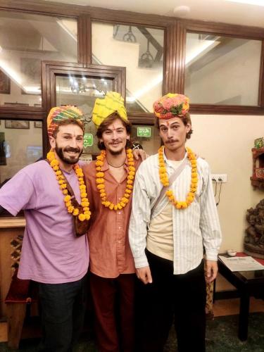 three men wearing turbans and hats posing for a picture at Little Ganesha Inn in Jaipur