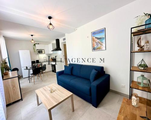 un salon avec un canapé bleu et une table dans l'établissement Studio Citadella Centre-ville CALVI, à Calvi
