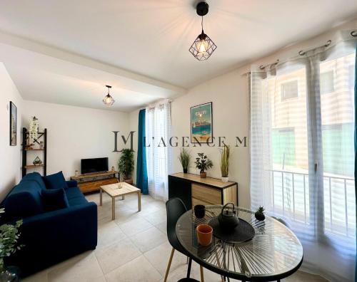 un salon avec un canapé bleu et une table en verre dans l'établissement Studio Citadella Centre-ville CALVI, à Calvi