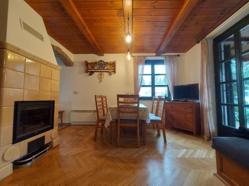 a dining room with a table and chairs and a television at Titi Boutique Apartmanok in Bükfürdő