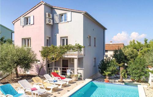 a villa with a swimming pool in front of a house at 1 Bedroom Amazing Apartment In Banjole in Banjole