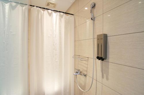 a shower in a bathroom with a shower curtain at Taipei Sunny Hostel in Taipei