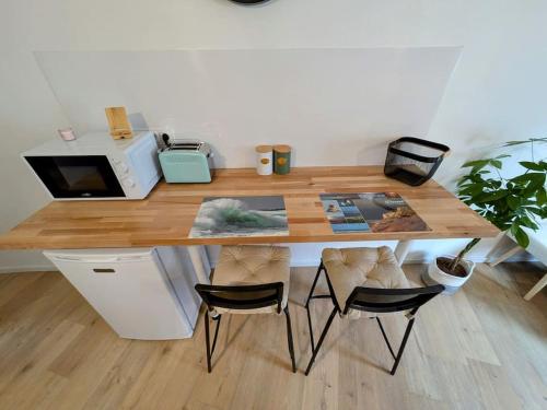 a wooden table with two chairs in a room at Au Petit Wissant in Marquise