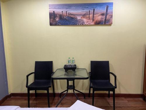 a table and two chairs in a room at Nawaporn Place in Phuket Town