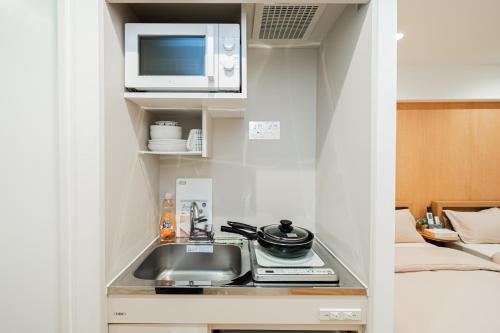 a kitchen with a sink and a microwave at Kiwami Hotel Shinjuku in Tokyo