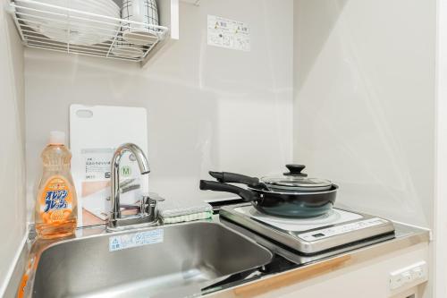 a kitchen sink with a pot on top of it at Kiwami Hotel Shinjuku in Tokyo