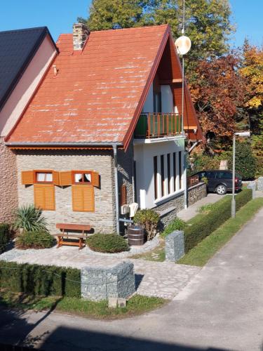 a house with an orange roof and a picnic table at Titi Boutique Apartmanok in Bükfürdő