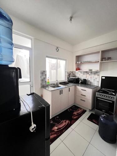 a kitchen with a black refrigerator and a stove at Buxton point 2 With Air Conditioner in Mombasa