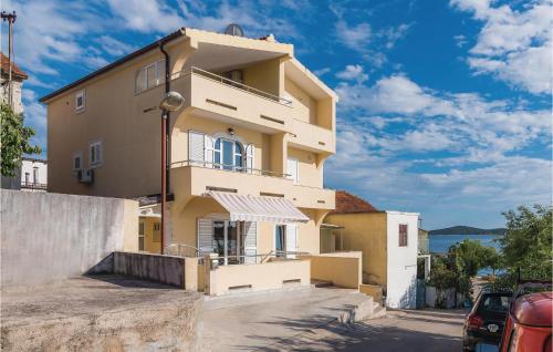 a yellow house with a balcony on a street at Three-Bedroom Holiday Home In Sibenik in Šibenik