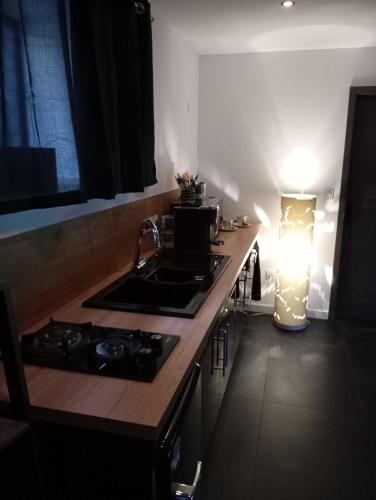 - une cuisine avec un évier et un comptoir lumineux dans l'établissement Balnéo SPA Allevard, à Allevard