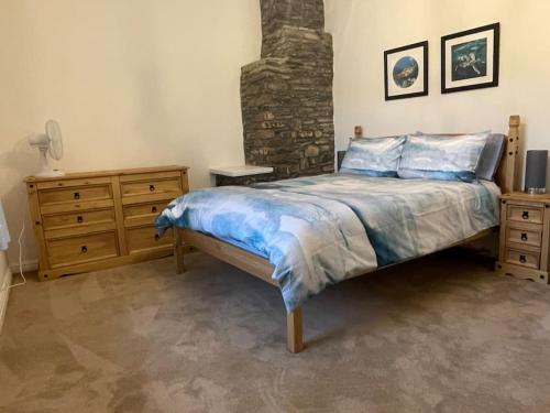 ein Schlafzimmer mit einem Bett und einem gemauerten Kamin in der Unterkunft Braunton Breaks - North Beach Cottage in Braunton