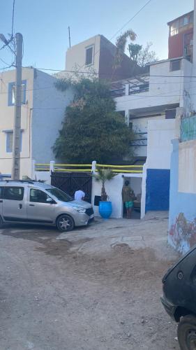 two cars parked in a parking lot next to a building at Yousef appartement in Taghazout
