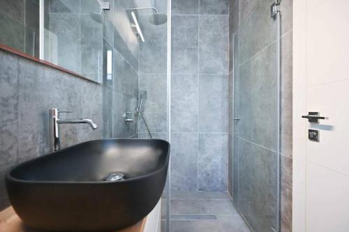 a bathroom with a black sink and a shower at Ben Yehuda Dream Penthouse in Tel Aviv