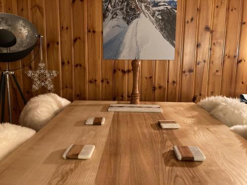 une table en bois avec une lampe au-dessus dans l'établissement Les Chevreuils, à Combloux
