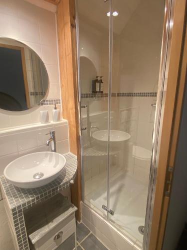 une salle de bain avec une douche en verre et un lavabo dans l'établissement Flora, à Les Brousses