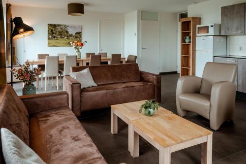 a living room with a couch and a table at Recreatie Landgoed Terlingerhoeve in Noorbeek